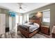 Bright main bedroom with wood-look floors, ceiling fan, French door, and decorative headboard at 27199 Punta Cabello Ct, Punta Gorda, FL 33983