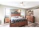 The main bedroom features wood-look floors, a ceiling fan and decorative headboard with matching dresser at 27199 Punta Cabello Ct, Punta Gorda, FL 33983