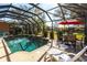 Beautiful screened-in pool area, perfect for relaxing and entertaining with table, chairs, and lounge at 27199 Punta Cabello Ct, Punta Gorda, FL 33983
