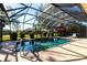 Enclosed pool area with clear blue water, outdoor seating, and lush landscaping at 27199 Punta Cabello Ct, Punta Gorda, FL 33983