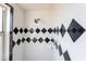 Stylish shower stall featuring black and white tiled walls and chrome showerhead at 27199 Punta Cabello Ct, Punta Gorda, FL 33983