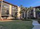 Multi-story building with manicured lawn, landscaping, and mature palm trees at 3006 Caring Way # 409, Port Charlotte, FL 33952