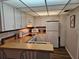 Efficient kitchen with white appliances, wood countertops, and updated backsplash at 3006 Caring Way # 409, Port Charlotte, FL 33952