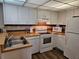 Well-maintained kitchen featuring white appliances, light wood counters, and white cabinetry at 3006 Caring Way # 409, Port Charlotte, FL 33952