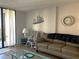 Comfortable living room boasts a couch, nautical décor, and sliding door access to the screened lanai at 3006 Caring Way # 409, Port Charlotte, FL 33952