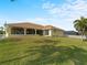 Spacious backyard with lush grass and a screened patio at 3370 Dover Dr, Punta Gorda, FL 33983