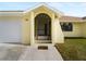 Front entrance of a light yellow house with a screened door and a paved walkway at 3370 Dover Dr, Punta Gorda, FL 33983