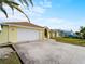 Yellow house with a white garage door and palm tree at 3370 Dover Dr, Punta Gorda, FL 33983