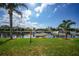 Waterfront backyard with a lawn, dock, and boats under a bright sky at 367 Coldeway Dr # H10, Punta Gorda, FL 33950