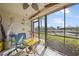 Enclosed lanai with waterfront view, table, ceiling fan, and sliding glass doors to the outside at 367 Coldeway Dr # H10, Punta Gorda, FL 33950