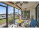 Screened-in lanai with a view of the water, ceiling fan, table, and bicycle at 367 Coldeway Dr # H10, Punta Gorda, FL 33950
