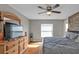 Primary bedroom featuring wood-look floors, natural light, ceiling fan, and a rustic accent wall at 4175 Horseshoe Ave, North Port, FL 34286