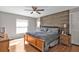 Primary bedroom showcasing a decorative wooden accent wall, ceiling fan, and wood-look flooring at 4175 Horseshoe Ave, North Port, FL 34286