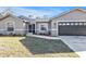 Charming single story house with gray exterior, attached garage, and lush green lawn and garden at 4175 Horseshoe Ave, North Port, FL 34286