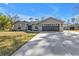 Charming single story house with gray exterior, attached garage, long driveway, and lush green lawn at 4175 Horseshoe Ave, North Port, FL 34286