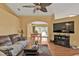Open living room leading to dining area with a comfortable sofa, ceiling fan, and a mounted television at 4175 Horseshoe Ave, North Port, FL 34286