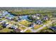 Aerial view of home situated on waterfront canal, surrounded by lush greenery and other residences at 4254 Bur St, Port Charlotte, FL 33948