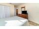 Bedroom featuring a dresser with mounted TV, white walls, and a view of the closet and hallway at 4254 Bur St, Port Charlotte, FL 33948