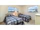 Bright bedroom with two twin beds, a nightstand with a lamp, and sunlit windows at 4254 Bur St, Port Charlotte, FL 33948