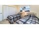 Bedroom featuring two twin beds, a nightstand with a lamp, and sunlit windows at 4254 Bur St, Port Charlotte, FL 33948