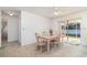 Bright dining room featuring neutral carpet, a ceiling fan and sliding glass door access to the lanai at 4254 Bur St, Port Charlotte, FL 33948