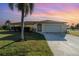 Single-story home at dusk with an arched entryway, a two-car garage, and professional landscaping at 4254 Bur St, Port Charlotte, FL 33948