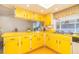 Bright kitchen with yellow cabinetry, countertops, an eat-in counter, and sunny natural light at 4254 Bur St, Port Charlotte, FL 33948