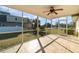 Screened in lanai featuring neutral tile flooring, a ceiling fan, and views of the back lawn at 4254 Bur St, Port Charlotte, FL 33948