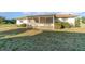 The rear exterior features a screened lanai overlooking a large yard and mature landscaping at 4254 Bur St, Port Charlotte, FL 33948