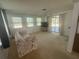 Inviting living room with large windows, ceiling fan, and sliding glass doors to the patio at 432 Olivia Rd, Venice, FL 34293