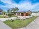Exterior view of a charming home with a lush lawn, solar panels, and long driveway at 530 Lakemont Nw Ave, Port Charlotte, FL 33952