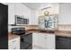 Well-lit kitchen featuring white cabinetry and black appliances at 530 Lakemont Nw Ave, Port Charlotte, FL 33952