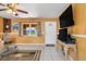 Inviting living room with tile floors, large window, ceiling fan, television and a welcoming ambiance at 530 Lakemont Nw Ave, Port Charlotte, FL 33952