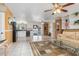 Open-concept living space with tile floors, a ceiling fan, a comfortable couch and seamless kitchen access at 530 Lakemont Nw Ave, Port Charlotte, FL 33952