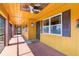 Cozy screened porch with sunny yellow walls, ceiling fan, and brick accents at 530 Lakemont Nw Ave, Port Charlotte, FL 33952