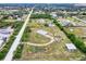Wide shot of the home on a large lot featuring mature landscaping, a small pond, and outbuildings at 6171 Swiss Blvd, Punta Gorda, FL 33982