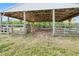 View of a covered wooden barn with a metal roof and gated openings for livestock or equipment at 6171 Swiss Blvd, Punta Gorda, FL 33982