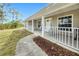 Inviting front porch with seating, white railings, and a landscaped walkway leading to the entrance at 6171 Swiss Blvd, Punta Gorda, FL 33982