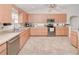 Bright kitchen with stainless steel appliances, light wood cabinets, and durable tile flooring at 6171 Swiss Blvd, Punta Gorda, FL 33982