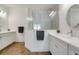 Spacious bathroom with double sinks, a glass-enclosed shower with marble-look tile, and wood-look tile floors at 6251 Cassia St, Bradenton, FL 34203