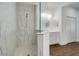 Bathroom with a glass-enclosed shower featuring marble-look tiles, a vanity, and access to the closet at 6251 Cassia St, Bradenton, FL 34203