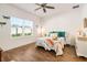 Bright bedroom featuring wood-look tile flooring, a ceiling fan, and a large window with a view of greenery at 6251 Cassia St, Bradenton, FL 34203