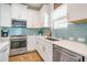 Modern kitchen featuring stainless steel appliances, light countertops and bright blue tiled backsplash at 6251 Cassia St, Bradenton, FL 34203
