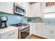 Close up of the stove and countertops in a kitchen with stylish blue backsplash and stainless appliances at 6251 Cassia St, Bradenton, FL 34203