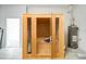 A beautiful wooden sauna with glass door and interior bench seating, complemented by a nearby water heater at 6251 Cassia St, Bradenton, FL 34203