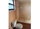Bathroom view of the toilet, tile shower, and window at 8152 Robert St, Englewood, FL 34224