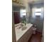 Bathroom with a white vanity, large mirror, and a shower with pinkish-red tiles at 8152 Robert St, Englewood, FL 34224