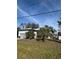 Front view of the single story home with trees and grass in the yard at 8152 Robert St, Englewood, FL 34224