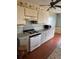 Kitchen with wood floors, white stove, and grey cabinets at 8152 Robert St, Englewood, FL 34224