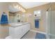 Bright bathroom featuring a double sink vanity, neutral walls, and glass enclosed shower at 7049 Waterford Pkwy, Punta Gorda, FL 33950